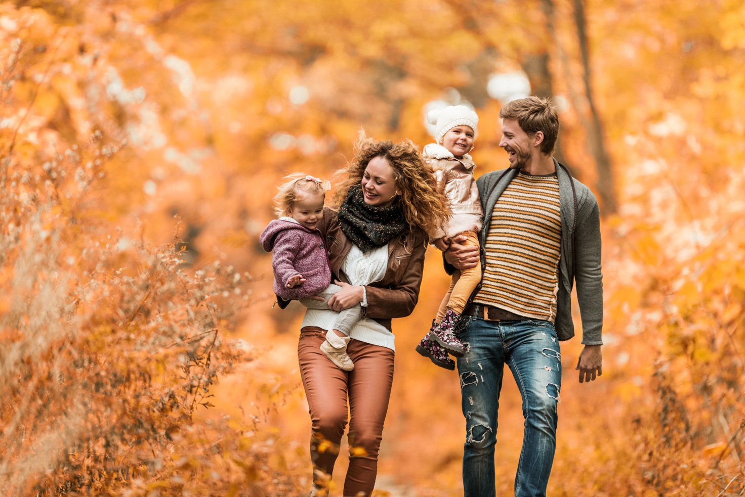 a family walking through an autumn forest